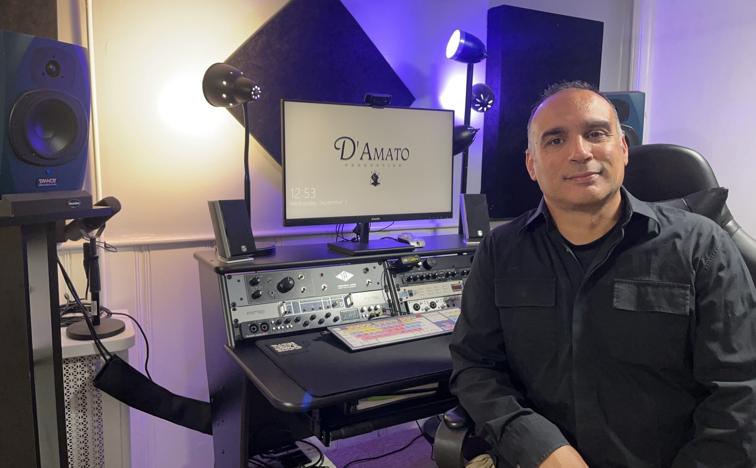 Michael D'Amato seated in his studio with monitors and audio equipment